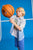 Child holding a basketball against a blue background