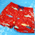 Red swim shorts with shark pattern on a blue water background