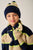 Child wearing a navy and beige striped sweater, navy hat, and matching scarf with green accents.